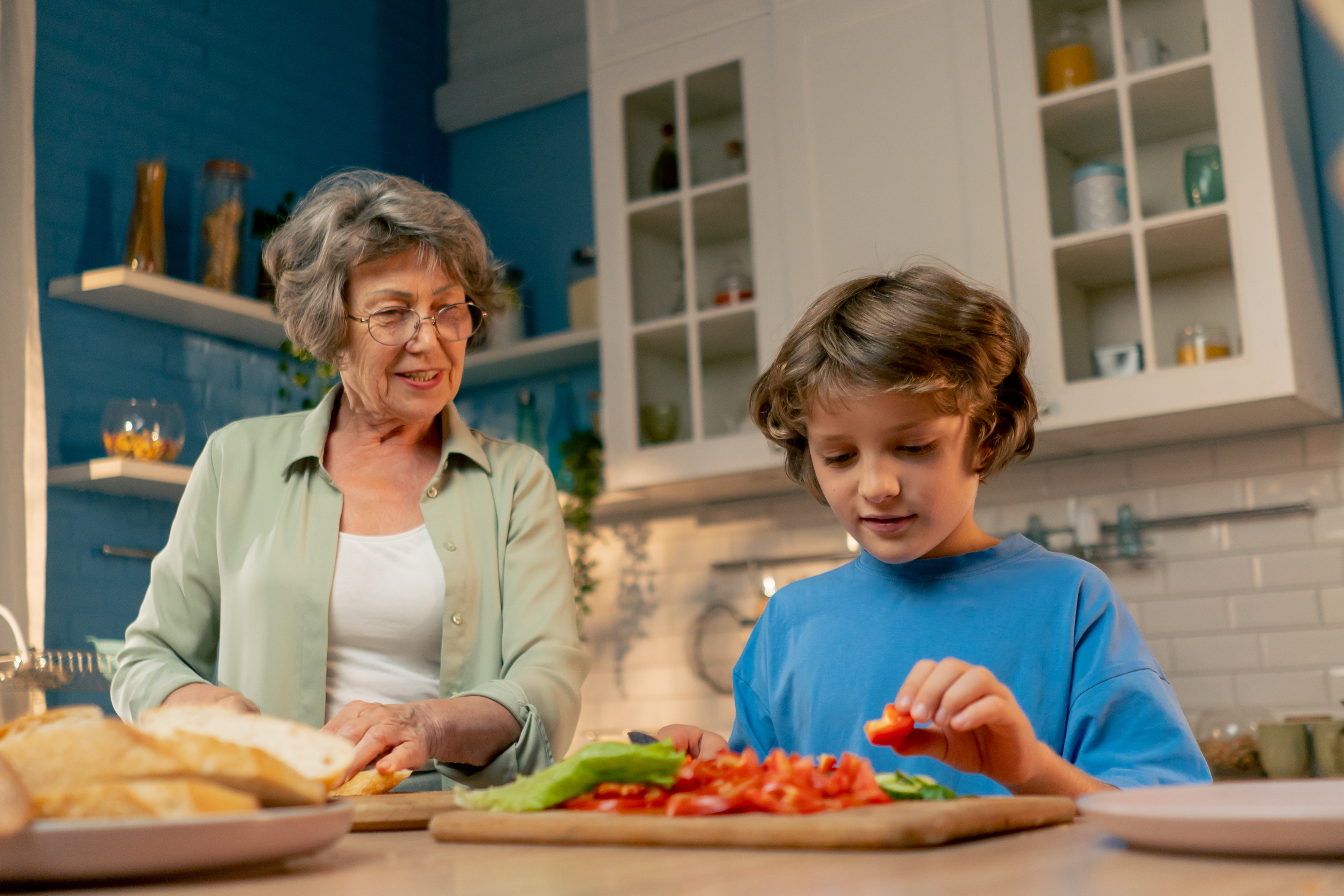 Woman chopping vegetables with grandchild